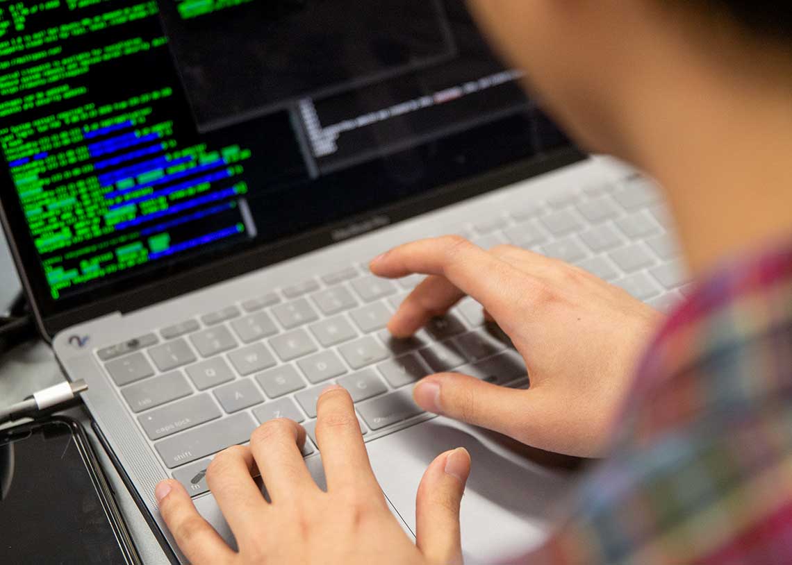 Image of a person typing on a laptop