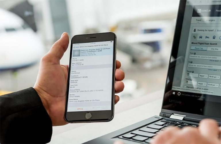 Someone using Concur Mobile and Laptop at airport