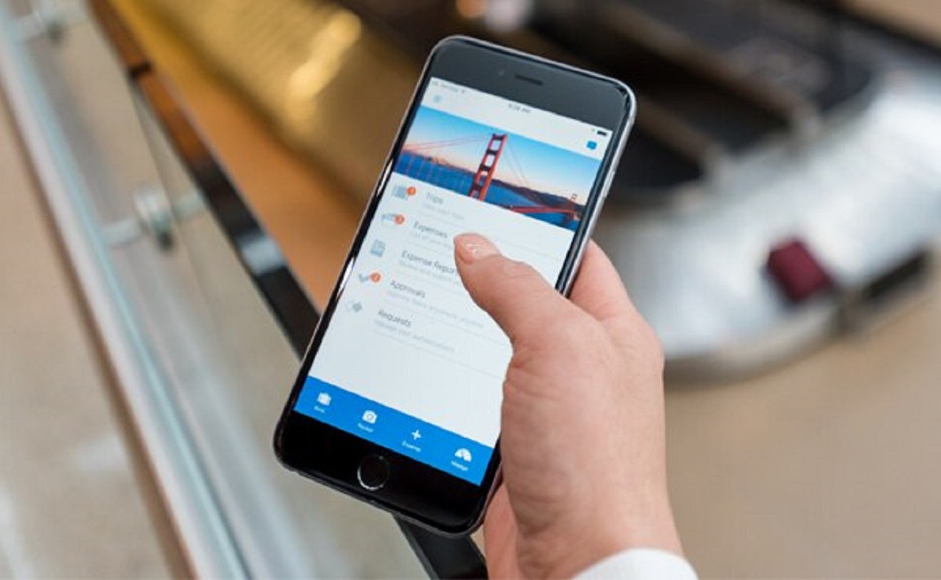 Hand holding cellphone using Concur Mobile App