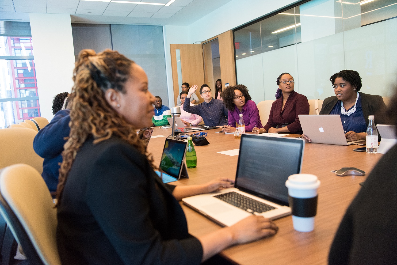 People sitting around a conference table with laptops